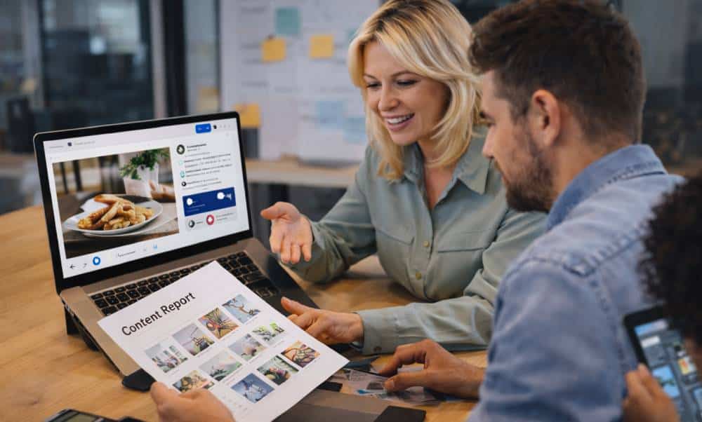 Discussing content report on laptop