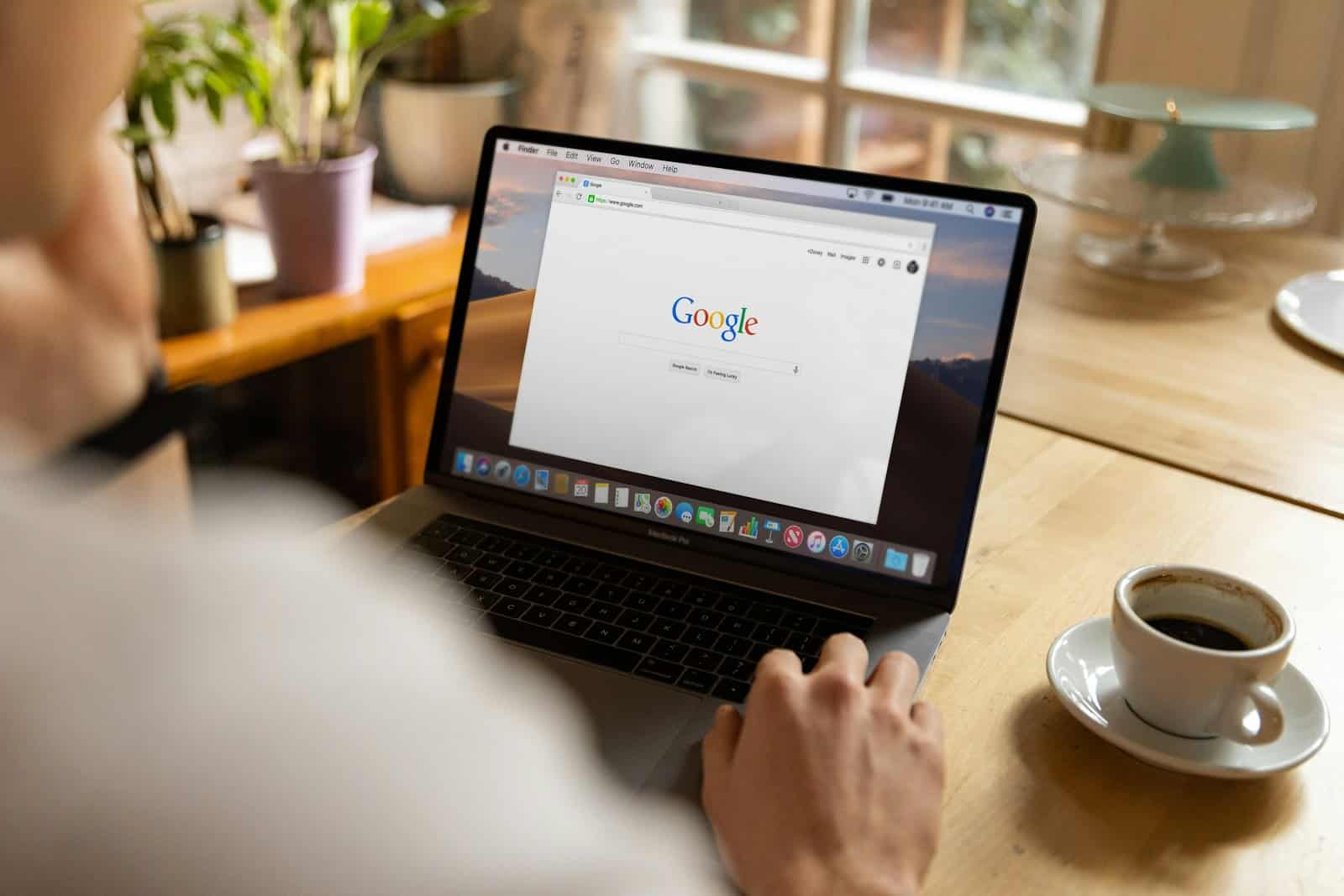 How Google Ads Generate High-Quality Leads Person searching Google on a laptop in a cafe